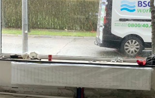 nouveau radiateur couvert d'une bâche et camionnette BSC visible par la fenêtre