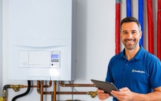 chauffagiste devant une chaudière murale