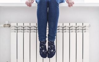 radiateur et femme assise sur le rebord de fenêtre