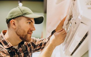 Un chauffagiste installe un système de climatiseur