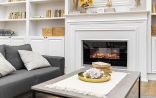 Insert cheminée dans un salon aux meubles blancs