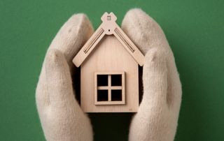 Deux mouffles entourent une petite maison en bois