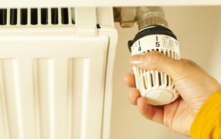 main qui tourne une vanne de radiateur