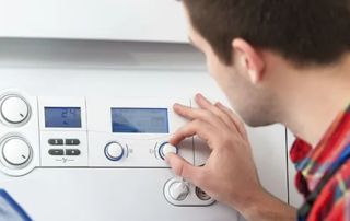 personne tournant un bouton sur un thermostat