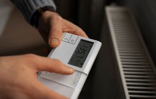 personne qui configure son thermostat